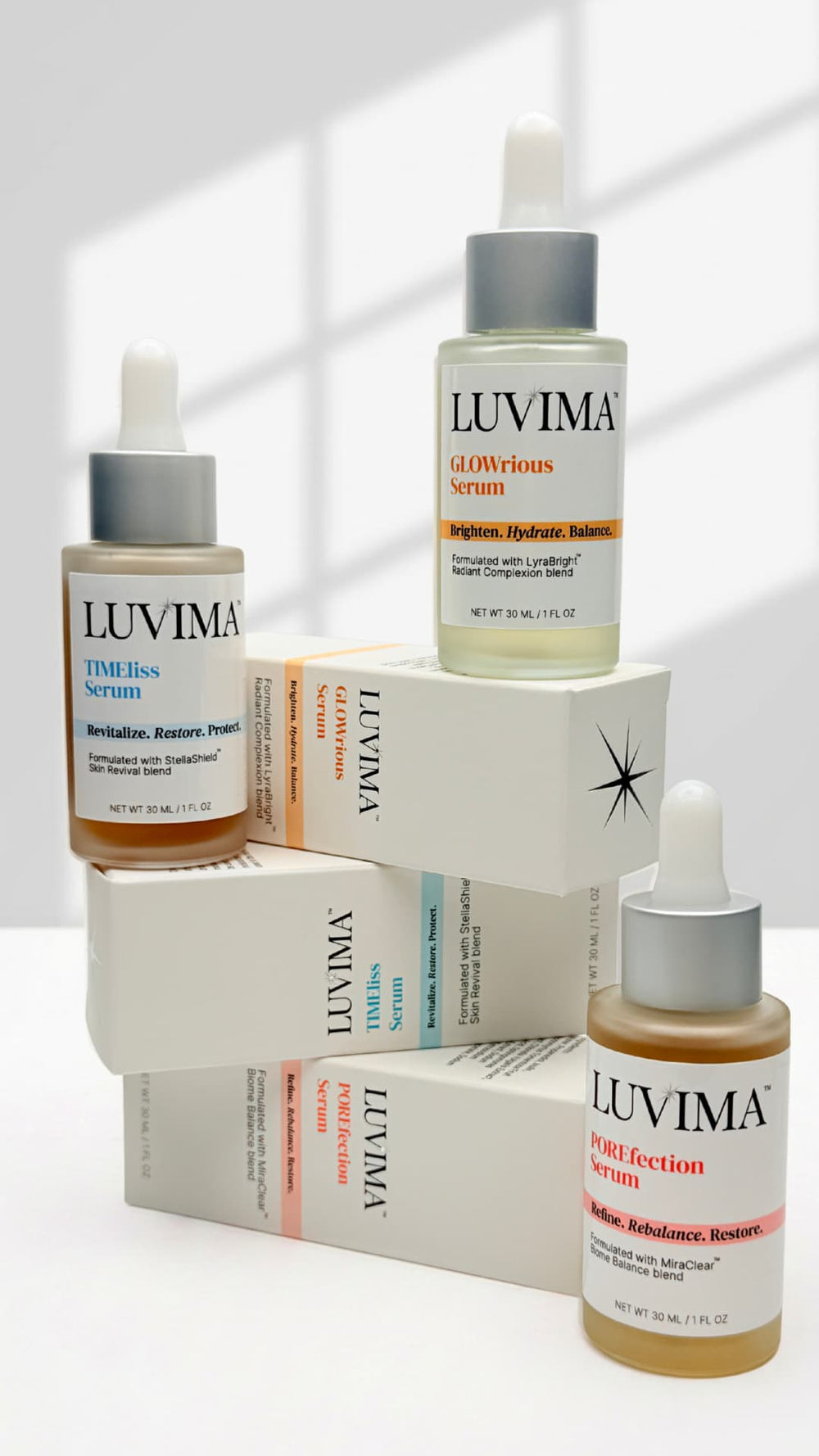 LUVIMA serum bottles stacked on top of packaging boxes on a white background